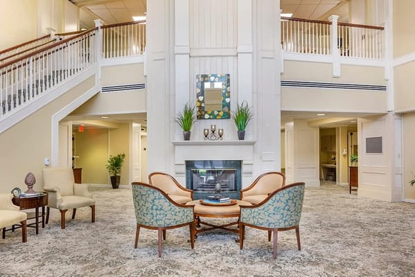 Bright interior common area with seating and a fireplace
