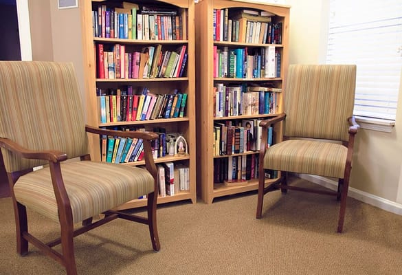 Comfortable chairs in a well-stocked library area