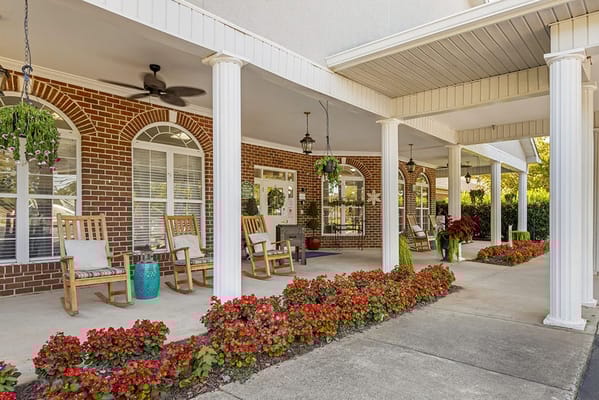 Outdoor patio area with flowers and rocking chairs
