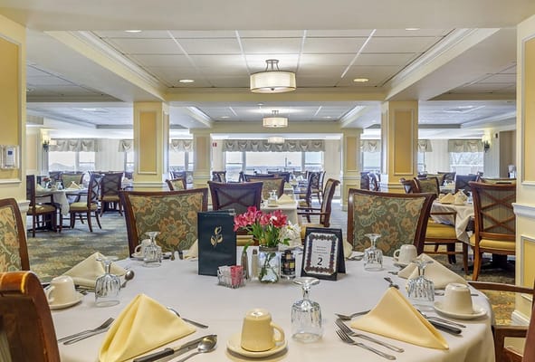 Dining room setup with tables and flowers.