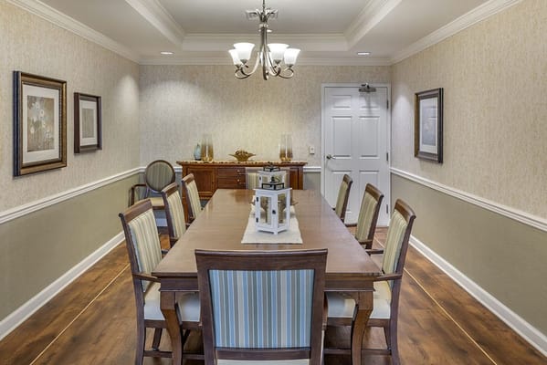 A bright dining area with a long wooden table and chairs