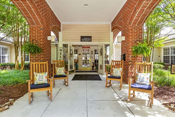 Outdoor welcome area with rocking chairs and greenery