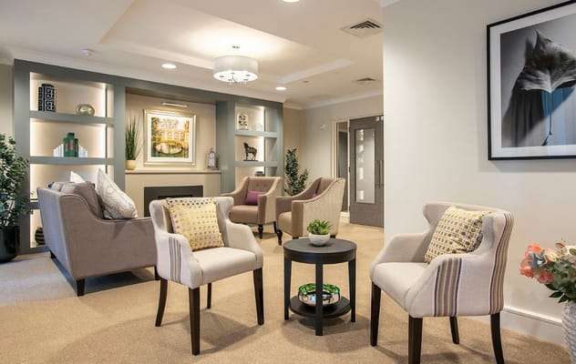 A cozy lounge area with comfortable seating and decorative shelves.