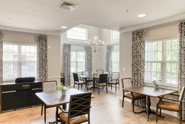 Bright dining area with tables and floral arrangements at Camellia Walk