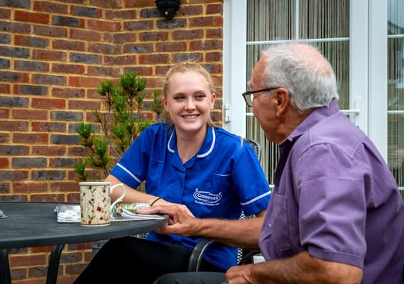 Caremark staff member enjoying time with a resident outdoors.