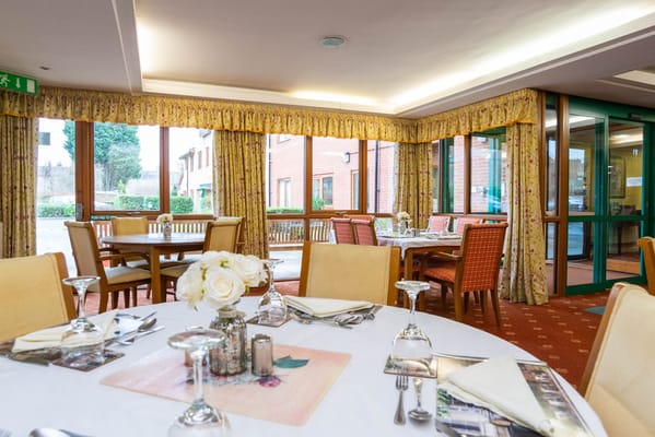 Dining room with tables set and flowers