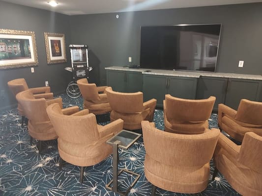 Interior lounge area with chairs facing a TV