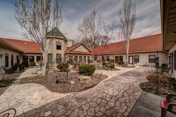 Outdoor courtyard of a senior living facility with pathways and gardens