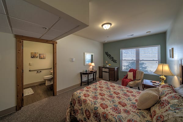 Private resident room with a bed and seating area