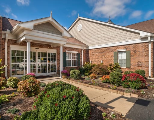 Entrance of a senior living facility with landscaped gardens