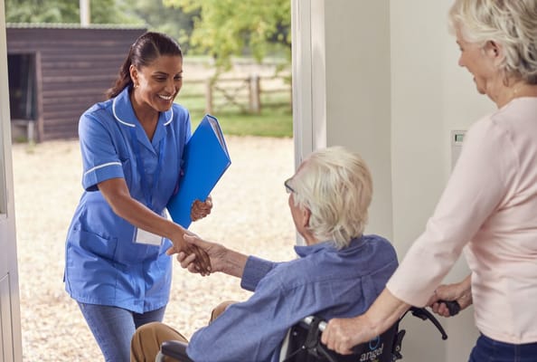 Caregiver greeting a resident at the entrance