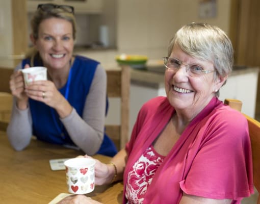 Two women enjoying drinks in a cozy indoor setting