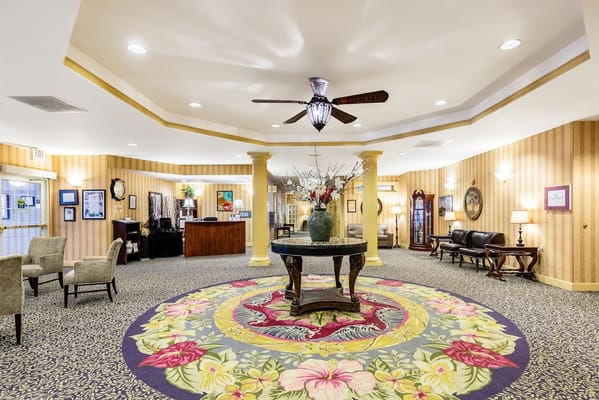 Welcoming lobby area with a floral rug and seating