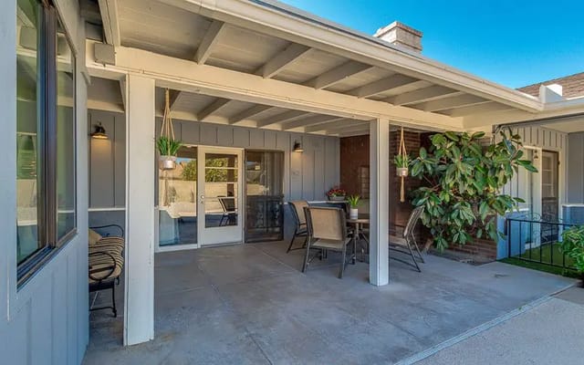 Outdoor patio area with seating and greenery