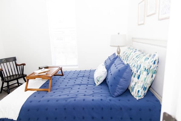 A cozy bedroom with blue accents and a bedside table