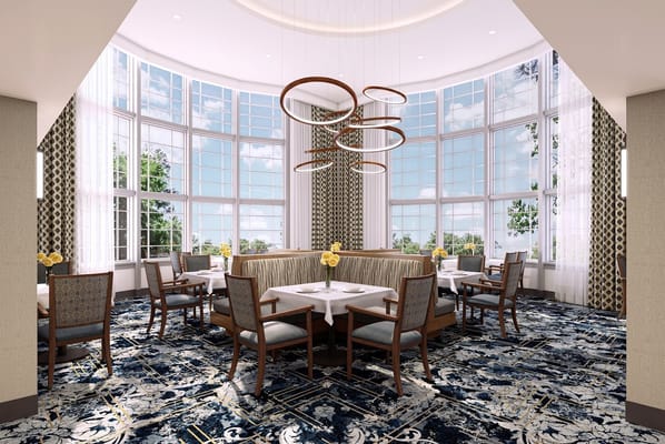 Bright dining room with large windows and floral centerpieces