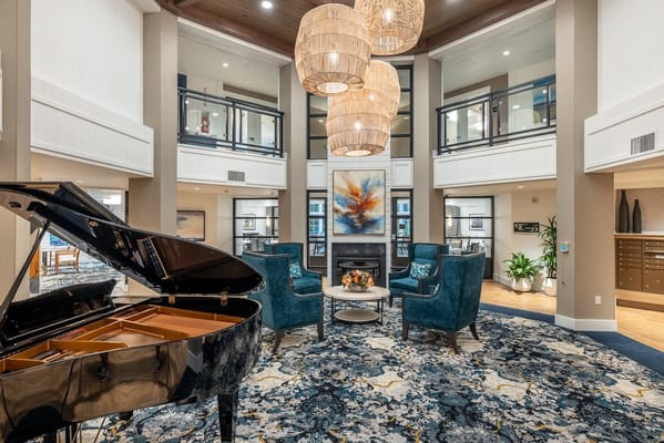 Bright and elegant common area with a piano and seating