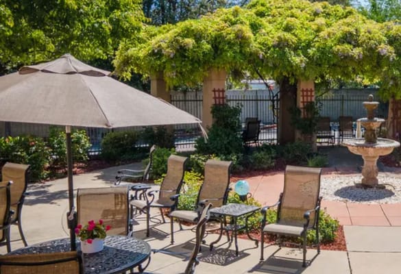 Outdoor seating area with a fountain and greenery