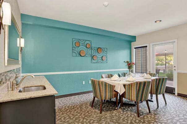 Bright dining area with colorful striped chairs and a table set for meal