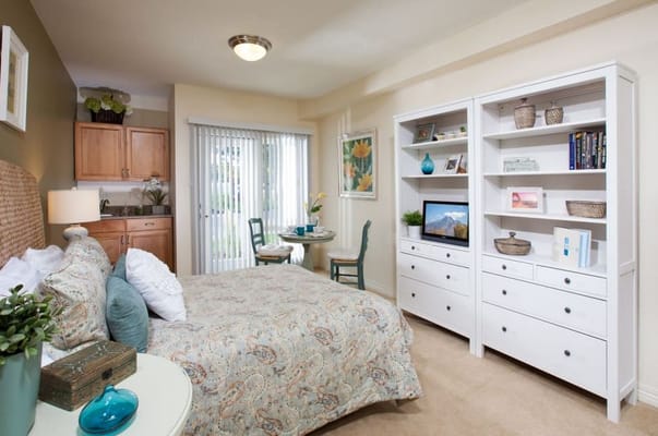 Bright and inviting bedroom with kitchen area and seating.