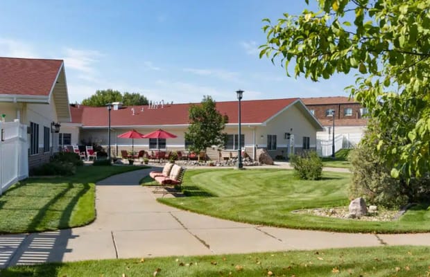 Lush green outdoor space with seating and umbrellas at Country House at Dickinson