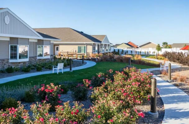 Well-maintained garden with flowers and walking paths outside the facility