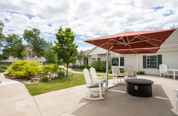 Outdoor seating area with shaded patio and greenery