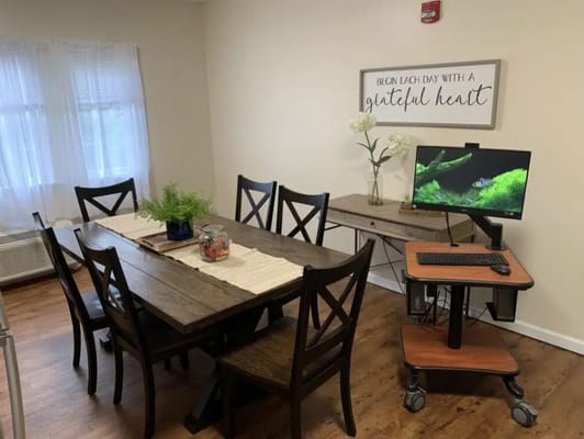 Bright dining area with wooden table and computer station