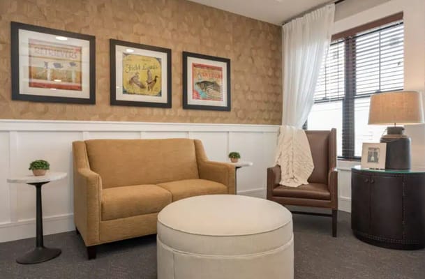 Cozy living room with a sofa, armchair, and decorative wall art