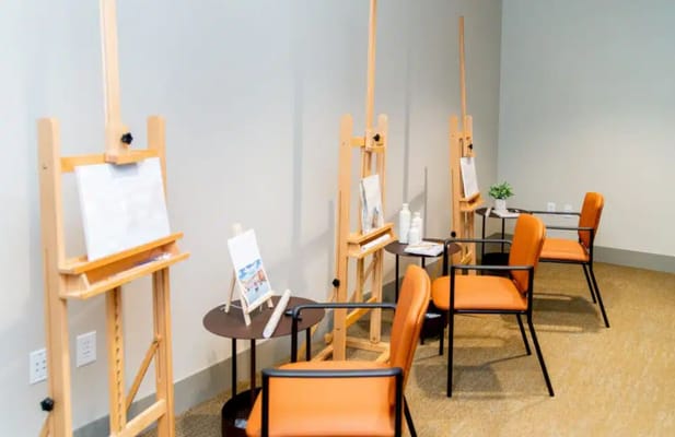 Art activity setup with easels and chairs in a bright room