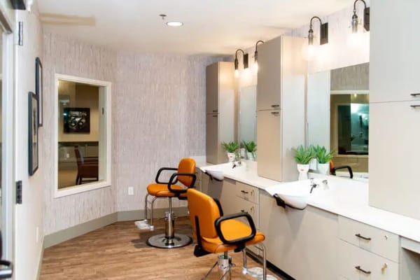 A salon area with chairs and mirrors