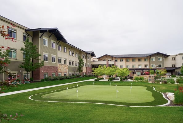 Exterior view of an assisted living facility with a putting green