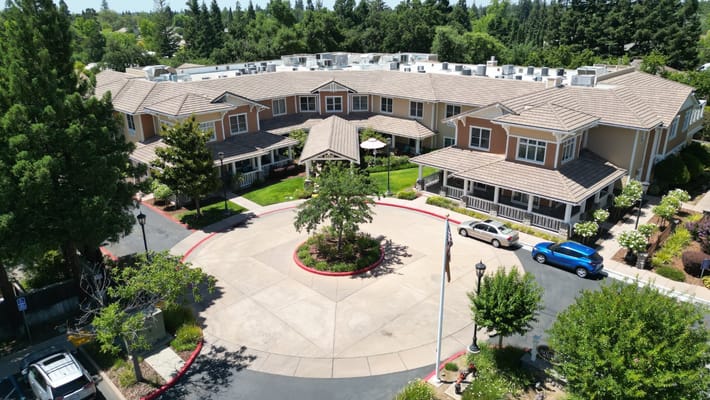 Aerial view of Sunrise of Carmichael senior living facility showcasing the entrance and surrounding greenery.