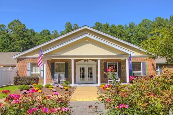 Exterior view of a nursing facility with flowers and flags