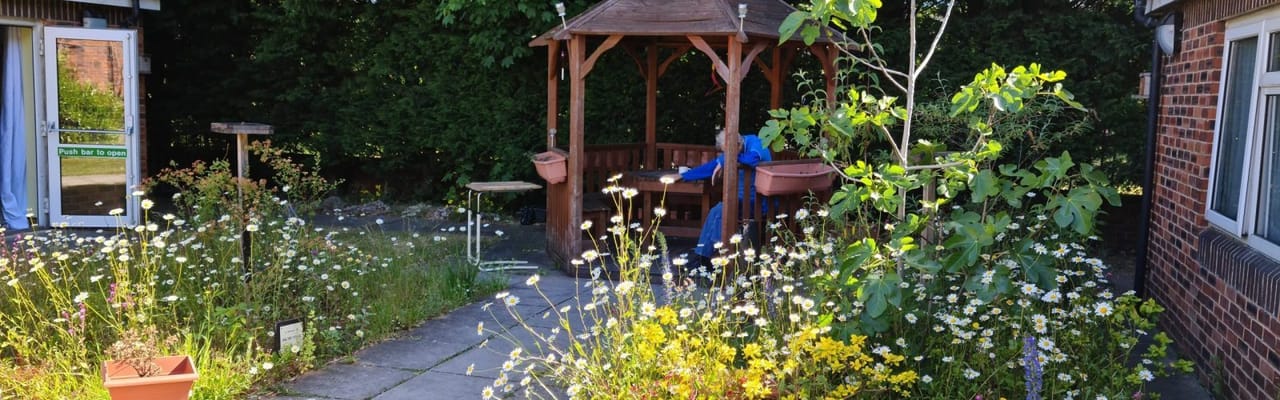A garden area with a gazebo and colorful flowers