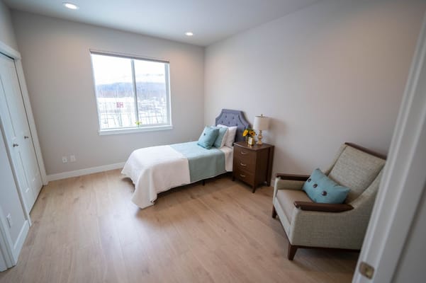 Cozy private room with a bed and chair