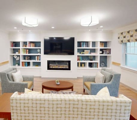 Cozy living room with armchairs, a sofa, and a fireplace.