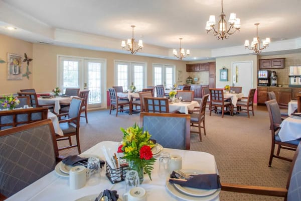Dining area set for a meal with flower centerpieces