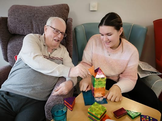 Resident and staff member engaging in a creative activity