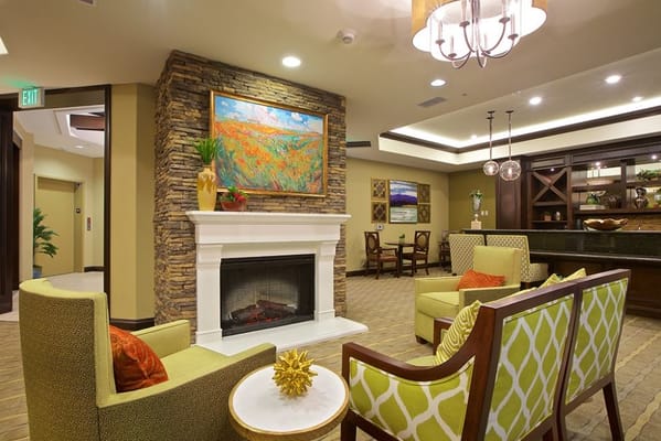 A cozy living room with green chairs and a fireplace