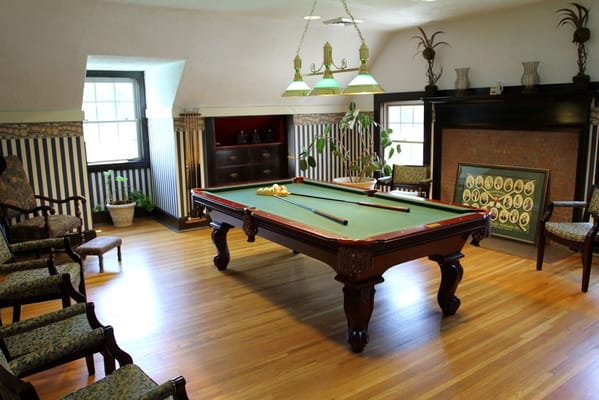 Billiards table in a lounge area with seating and decorative elements