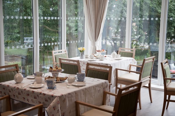Dining room set up for a meal with flowers and tableware