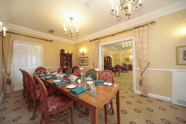 Elegant dining room with a large table set for guests.