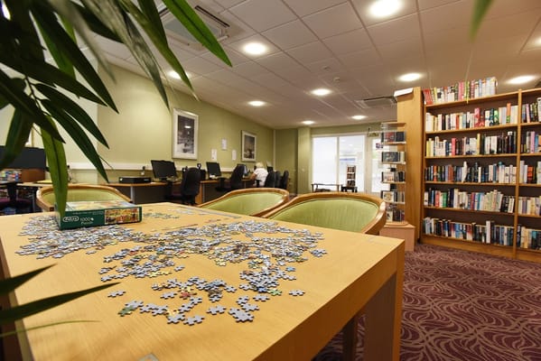 Residents engaged in a puzzle activity in the library