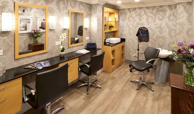 Interior of the hair salon featuring mirrors, styling chairs, and a sink.