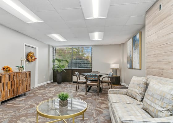 Bright common area with seating and dining space at Heritage Place.