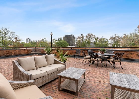 Seating area with couches and tables on a rooftop patio.