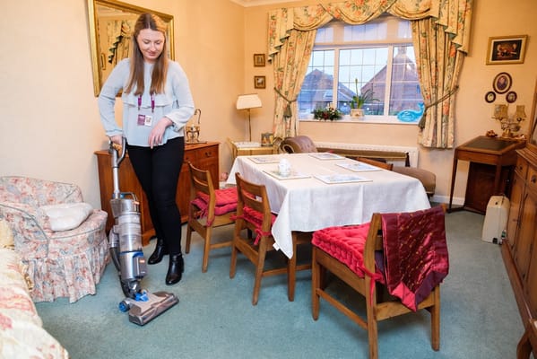 Staff member cleaning a cozy common area