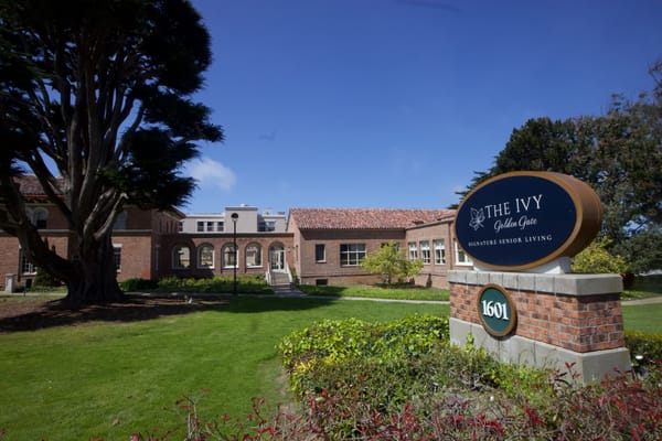 Outdoor view of The Ivy at Golden Gate with landscaping and sign.