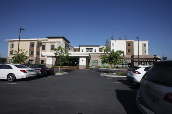 Front view of Belmont Village Senior Living facility with parking area